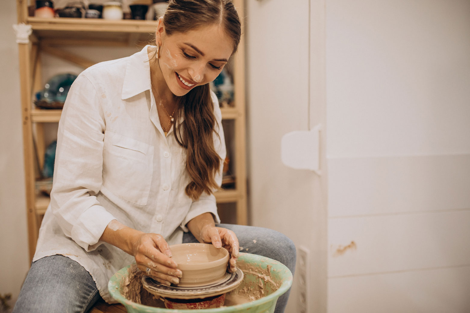 A member of the crafts community making pottery.